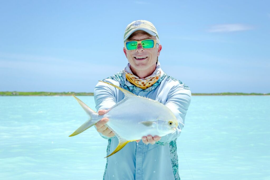 Angler wearing sunglasses with his catch during Exciting Spring Tides