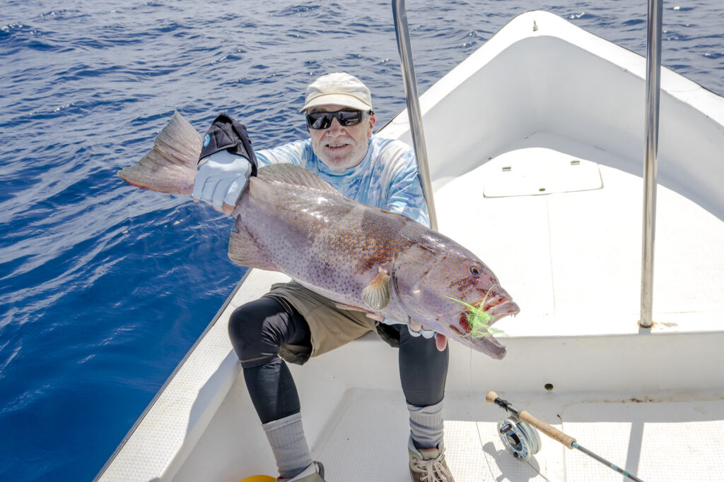 Fly fishing angler with his catch at Astove Atoll