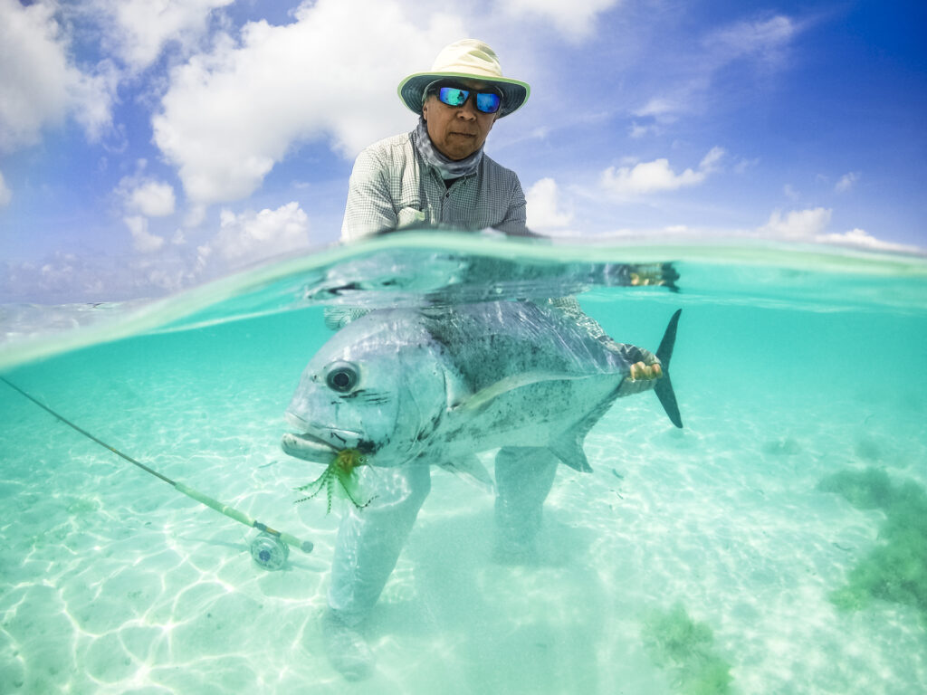 Fisherman releasing a giant trevally