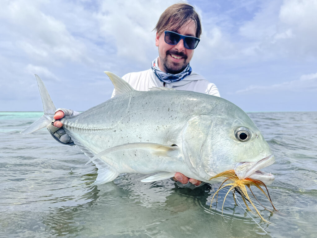 Angler with a GT caught on fly at Cosmoledo Atoll