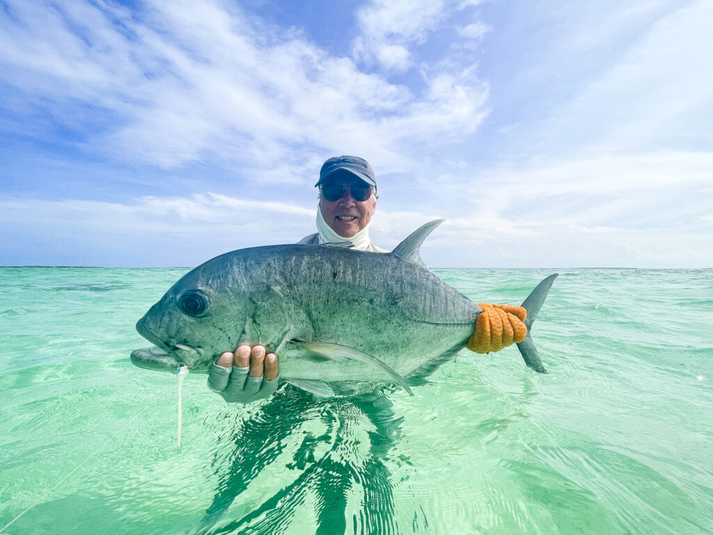 Fisherman with a GT he caught at Cosmoledo Atoll