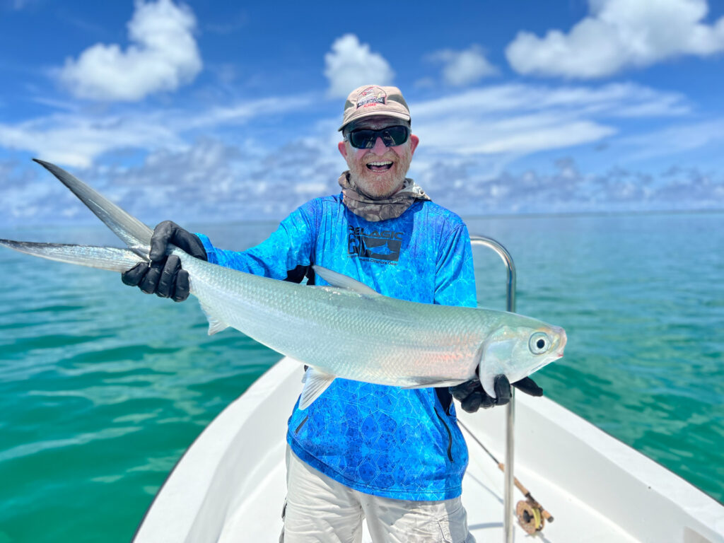 Angler with a monster of a milkfish at Cosmoledo Atoll