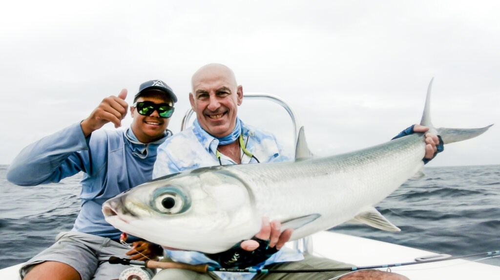 Men holding milkfish measuring a heafty size