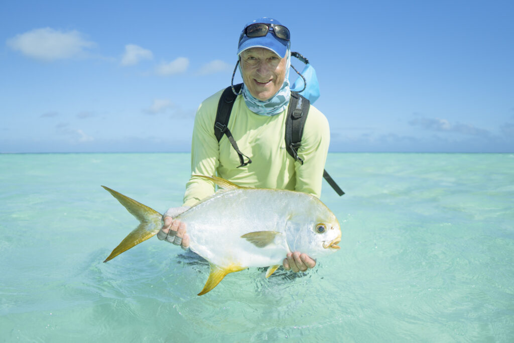 man holding Indo Pacific permit measuring a decent size