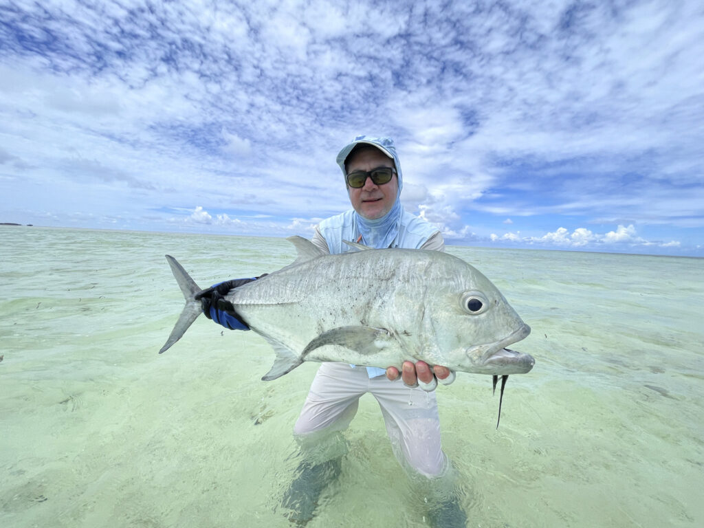 Angler holding up a tropical fish in the Seychelles