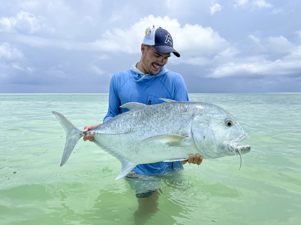 Angler holding a giant trevally landed at Alphonse Island