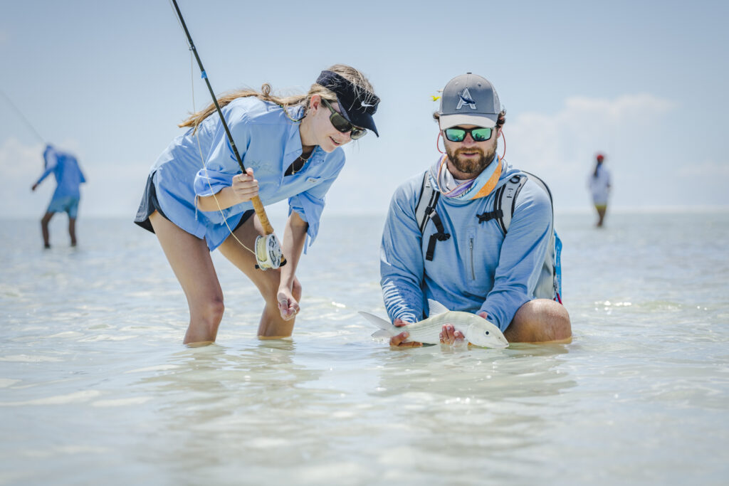 Guide helping fly fishing guest