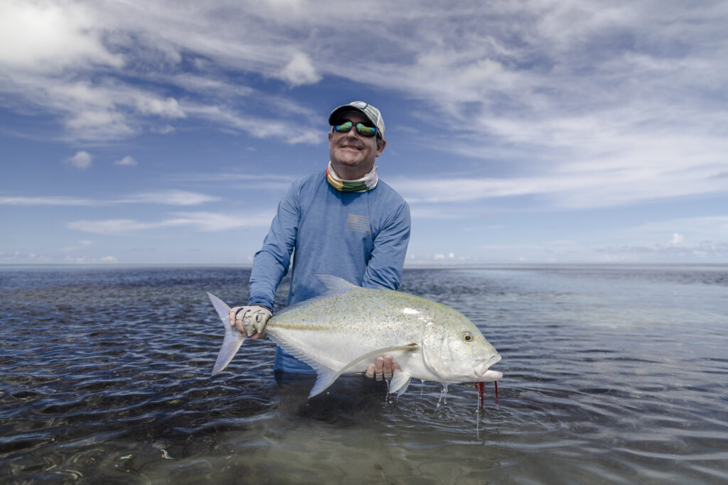 Fisherman with his catch, a bluefin trevally