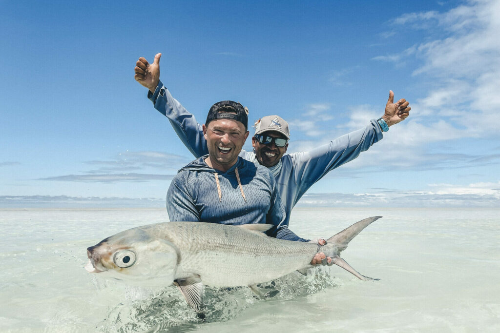Fishermen showing off a milkfish landed on the fly