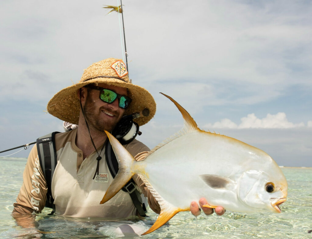 A permit fish being released by a fisherman