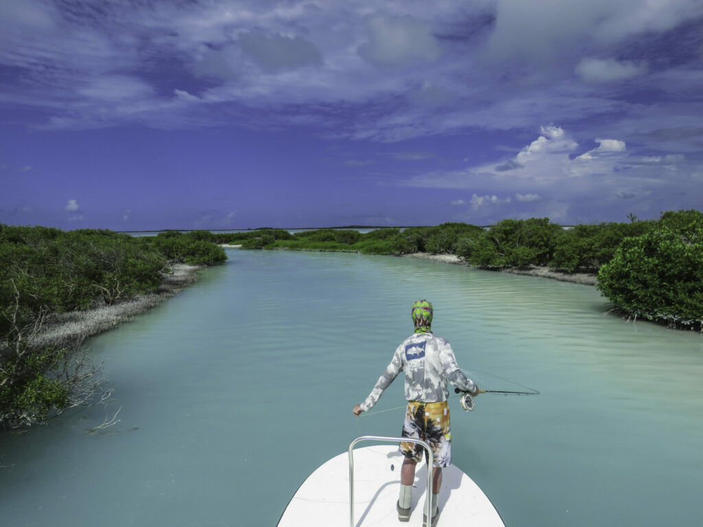 Angler on a skiff fly fishing at the wild Astove Atoll