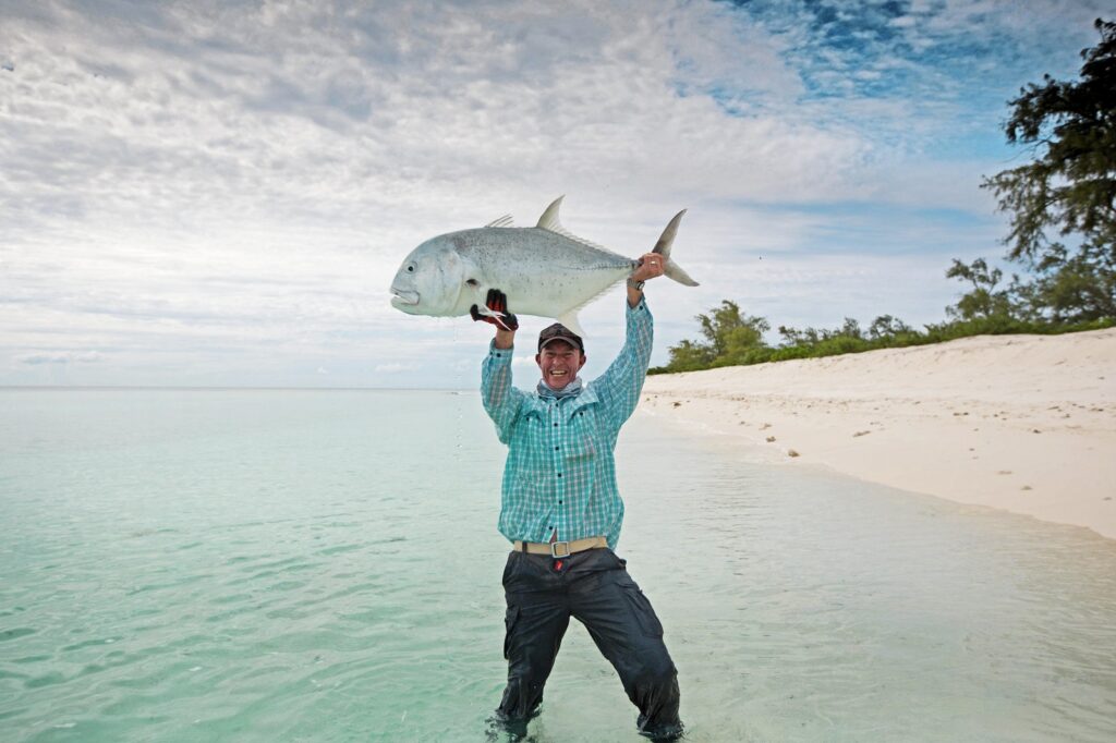 A dream come true moment of this fly fisherman holding his giant trevally caught on a fly.